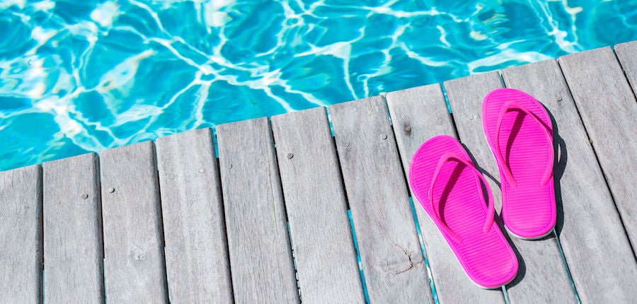 Pink flip flops by the swimming pool